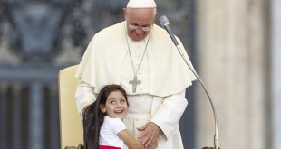 A young girl smiles as she embraces Pope Francis during an audience for families participating in the pastoral conference of the Diocese of Rome in St. Peter's Square at the Vatican June 14. (CNS photo/Giampiero Sposito, Reuters) See POPE-PARENTS June 15, 2015.